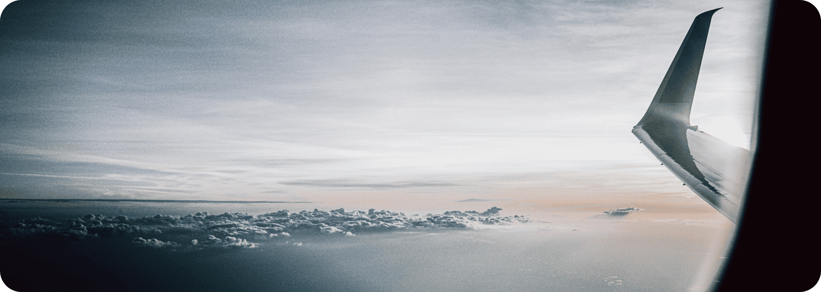 Image of an aeroplane wing over the clouds